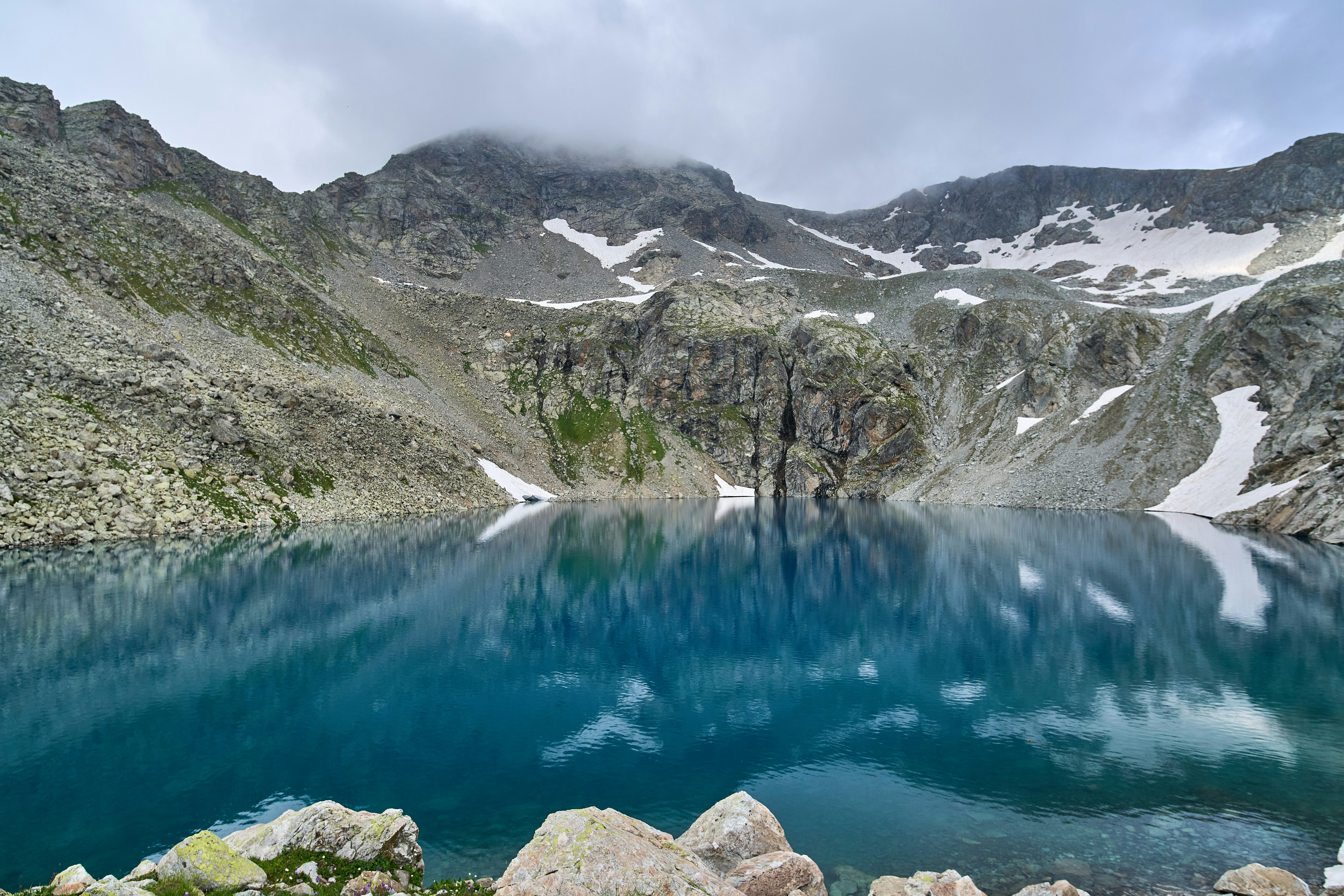 Горное озеро, окружённое заснеженными горами