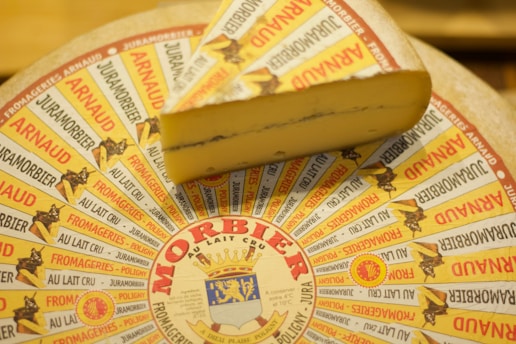 A cheese wheel with a piece of cheese on top of it