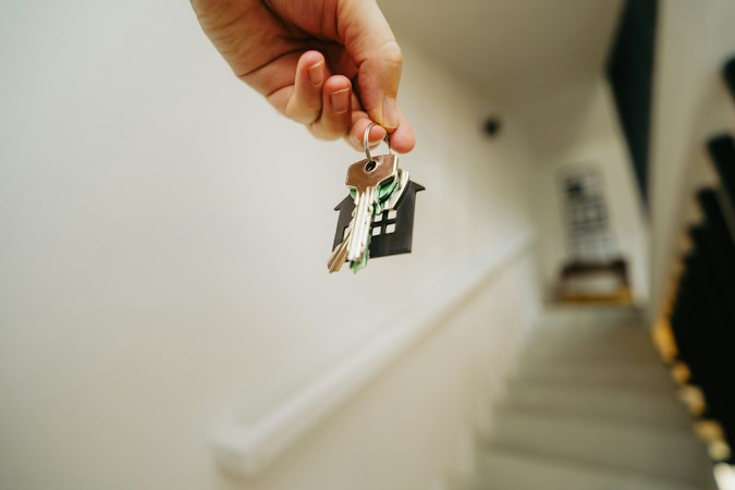 A person holding a house key, symbolizing the moment a rental search finally ends