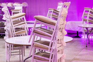 A room filled with lots of white tables and chairs