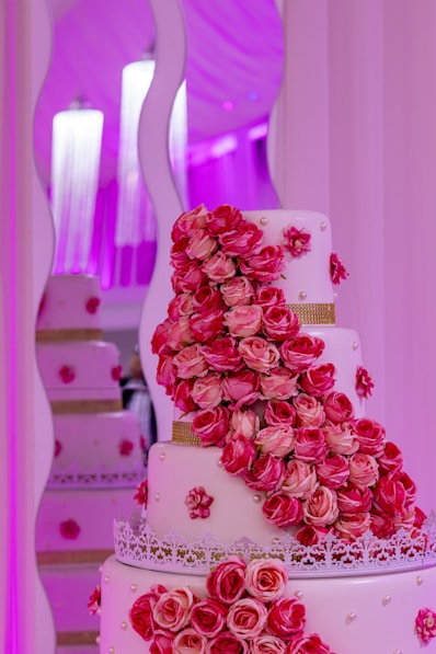 A wedding cake with pink roses on it
