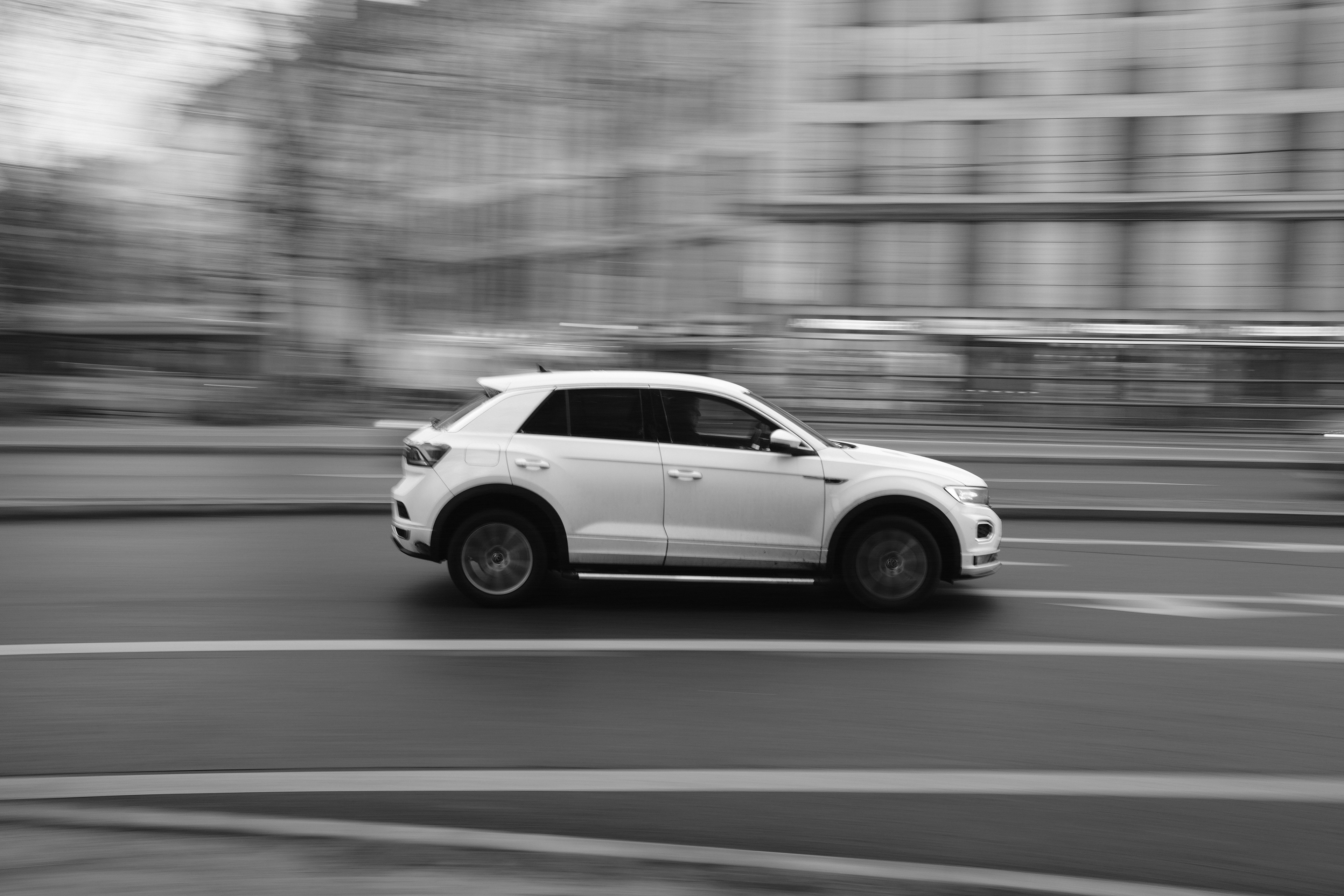 街の通りを走る白い車