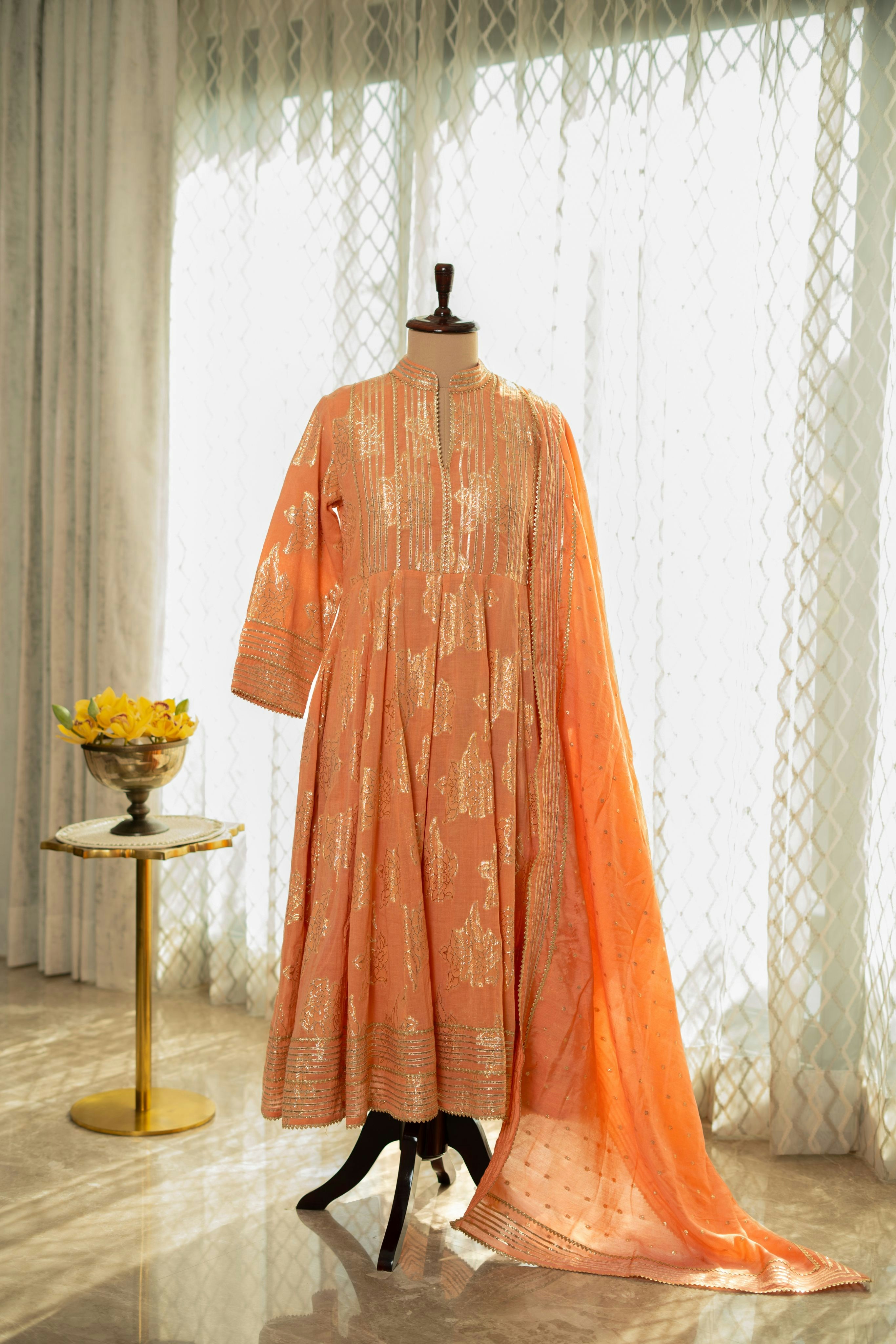 A dress on a mannequin in front of a window