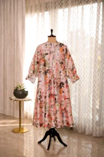 A dress on a mannequin in front of a window
