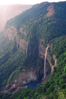 A waterfall in the middle of a lush green valley