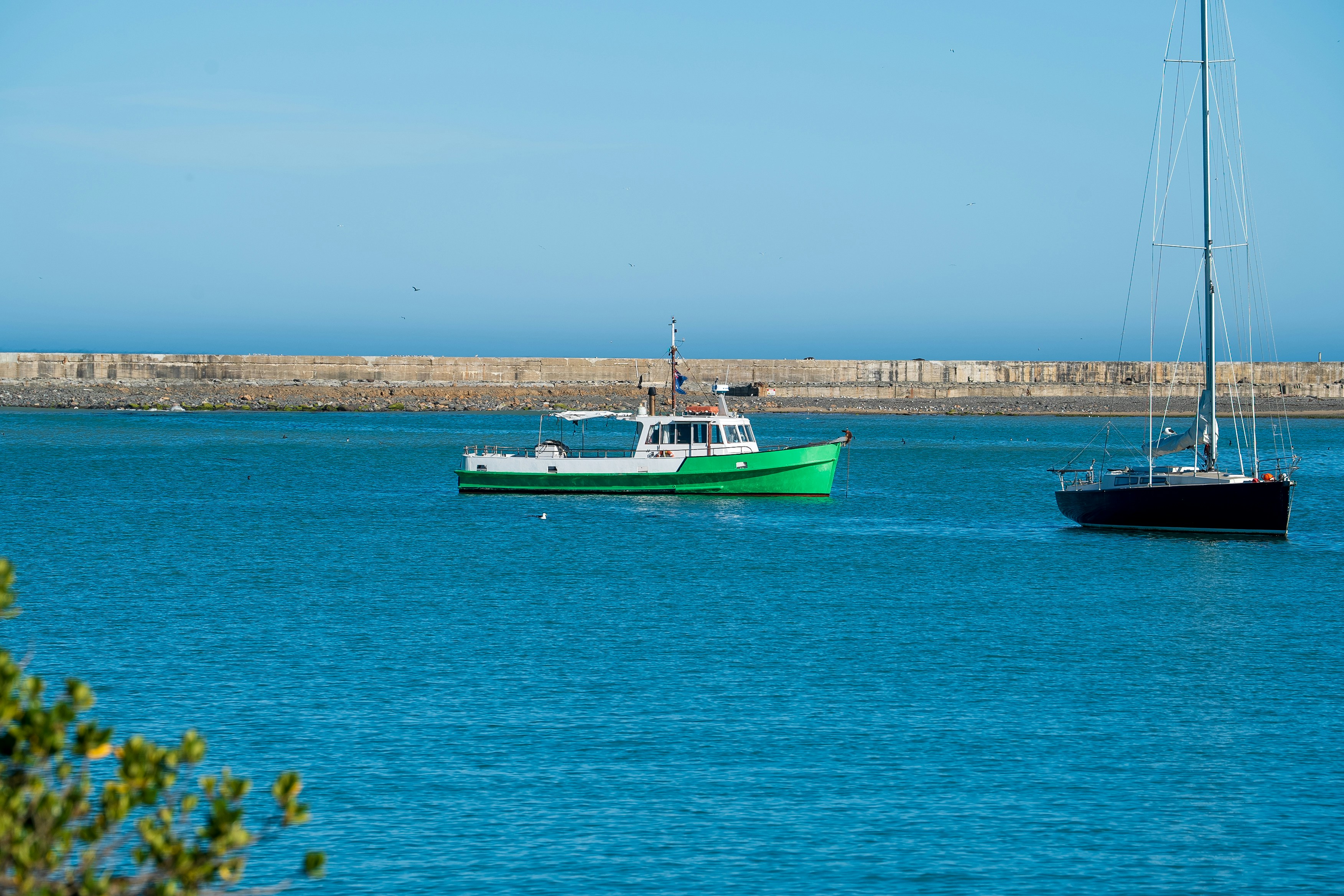 A couple of boats floating on top of a body of water
