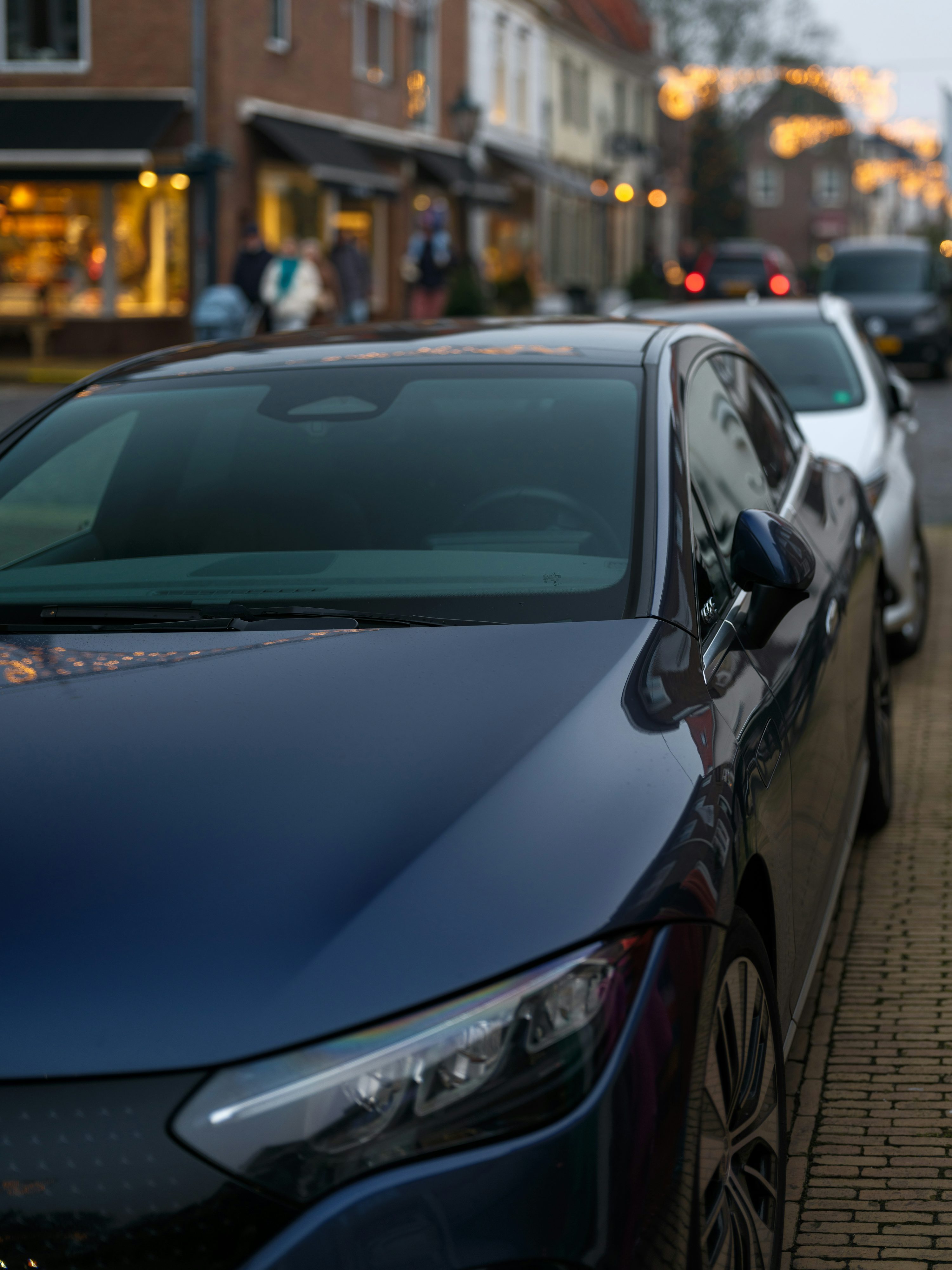 A blue car parked on the side of a street