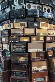 A large stack of old radio's sitting on top of each other