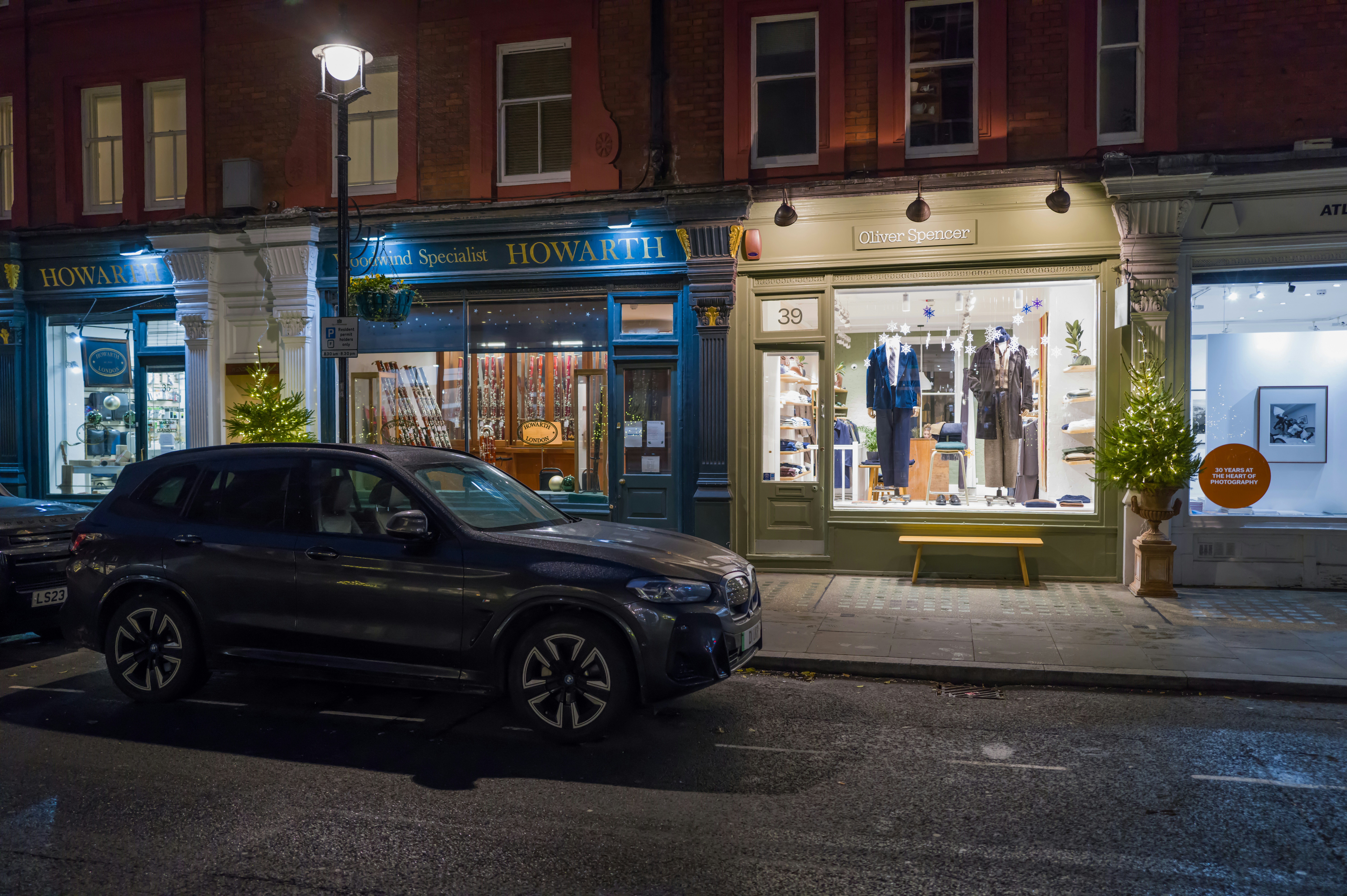A couple of cars parked in front of a store