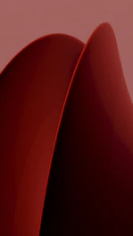 A close up of a red object on a pink background