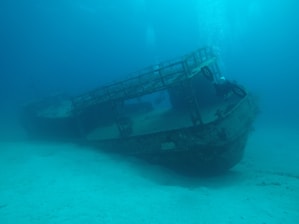 An old boat sitting in the middle of the ocean