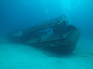 An old boat sitting in the middle of the ocean