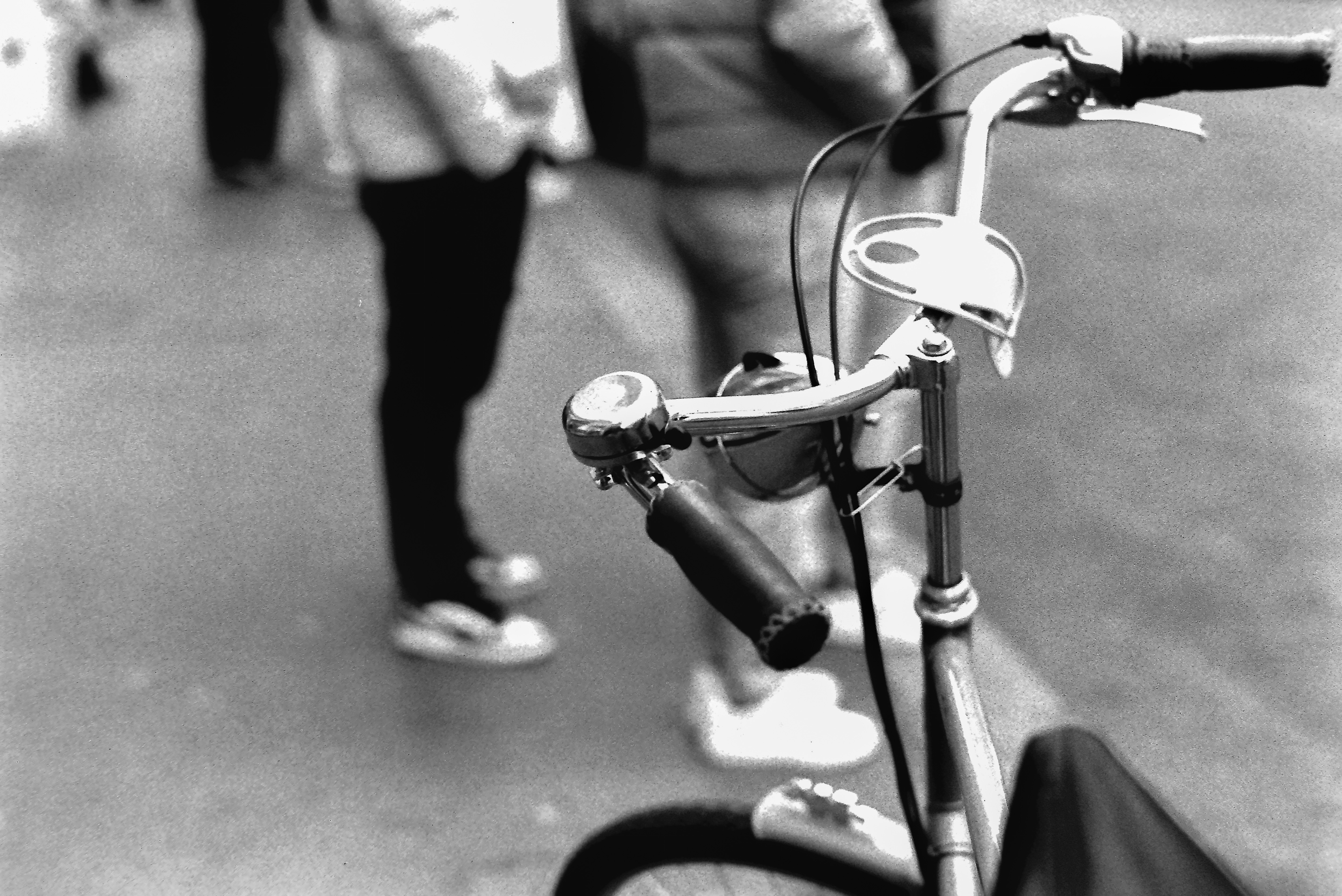 A black and white photo of a bicycle and people