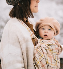 A woman holding a baby wrapped in a blanket