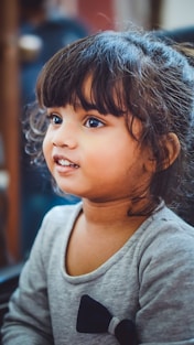 A little girl that is sitting in a chair