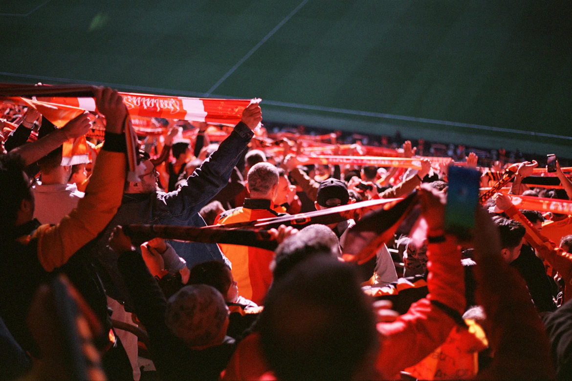 Football fans waving scarves in stadium