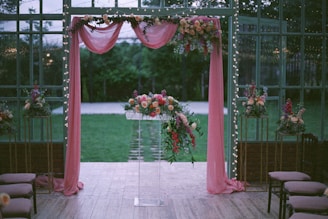 A wedding ceremony set up with pink drapes and flowers