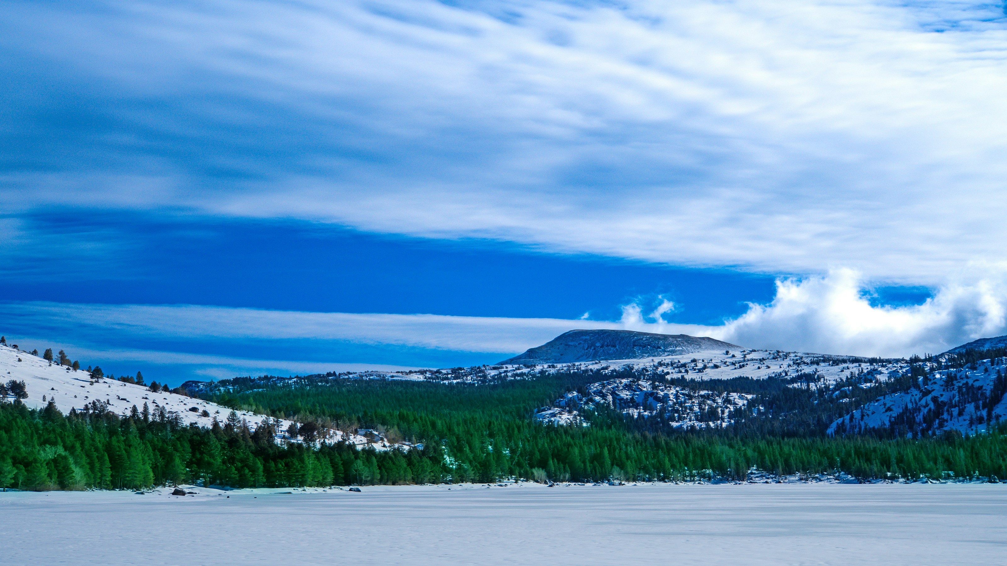 A snow covered field with mountains in the background