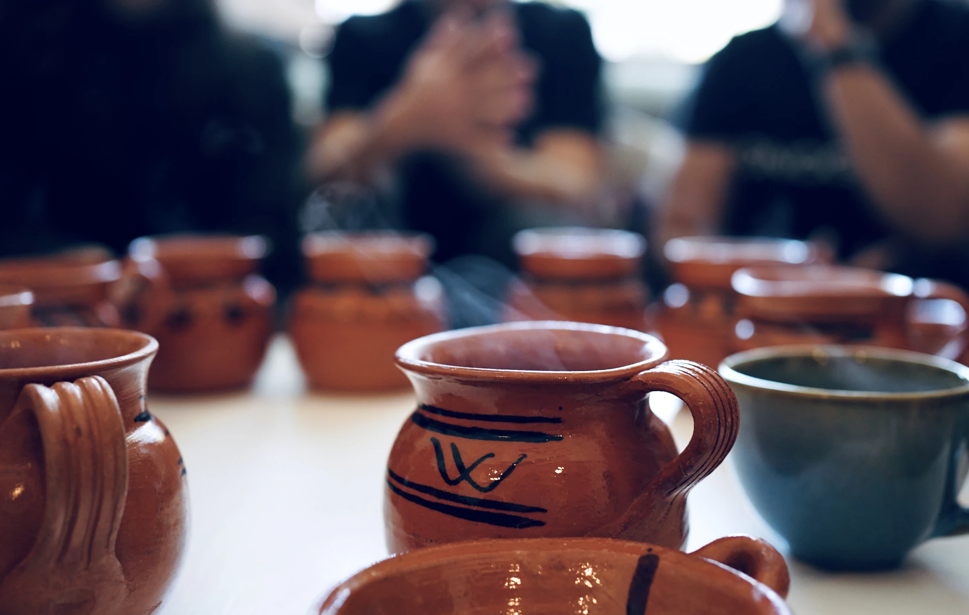 A table topped with lots of brown cups