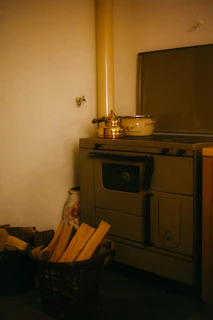 A kitchen with a stove and a basket of wood