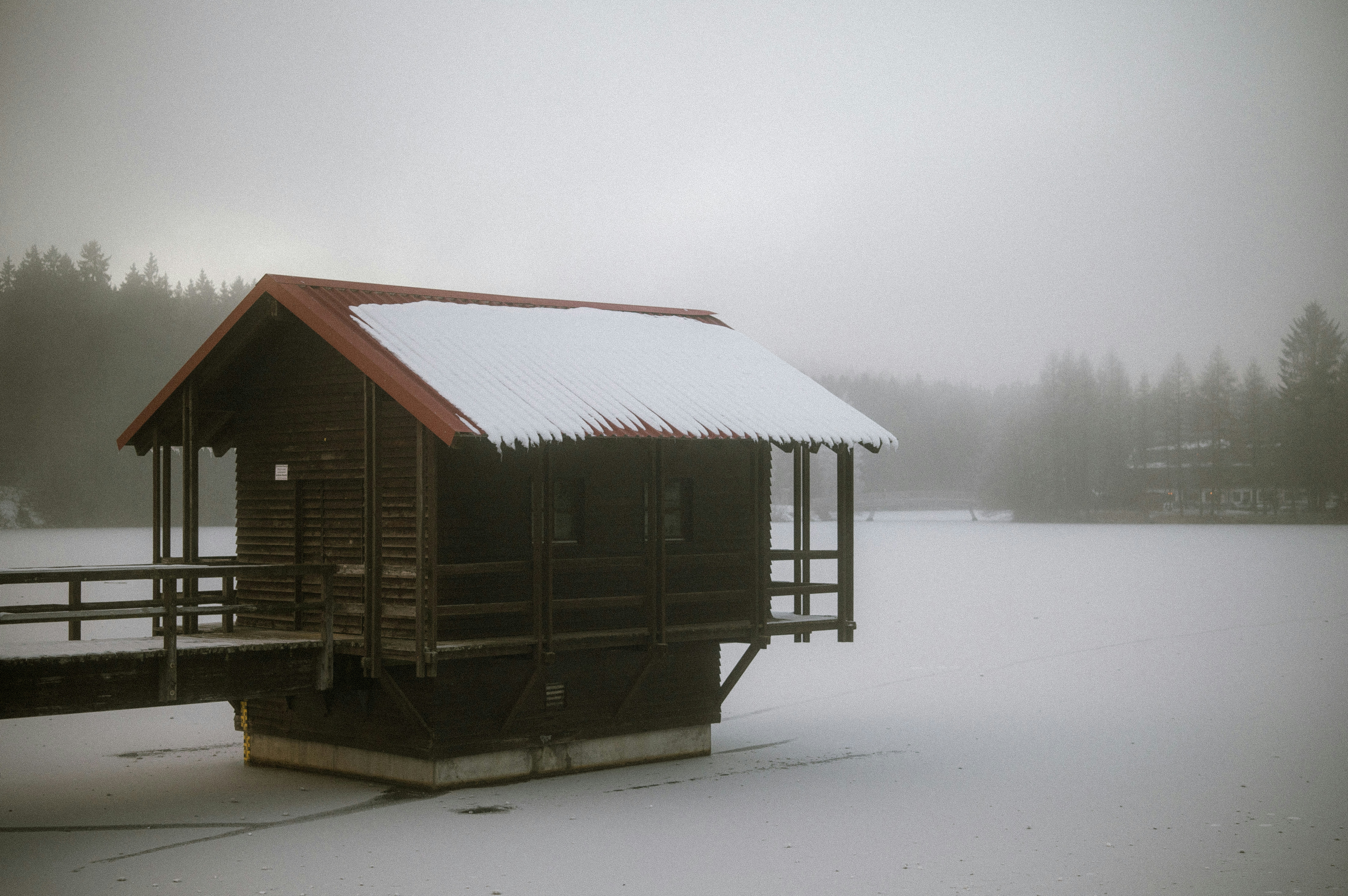 A small cabin sitting on top of a snow covered field