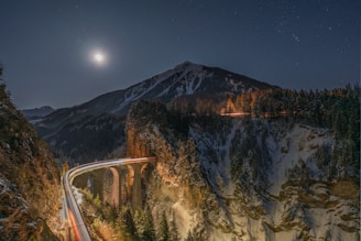 A long winding road in the mountains at night