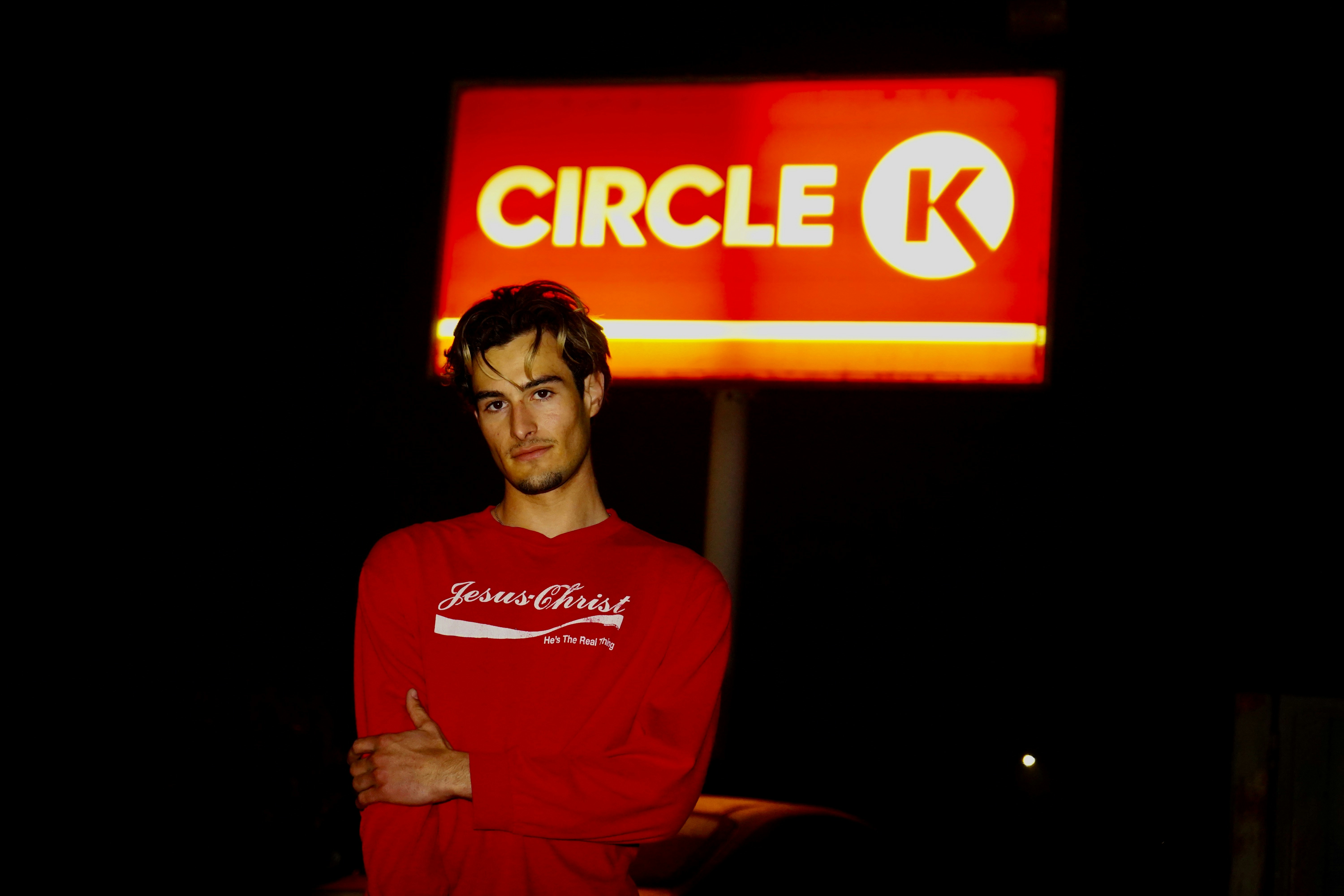 A man standing in front of a circle k sign