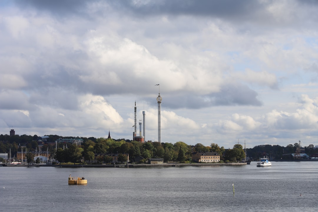 A body of water with boats floating on it, A Djurgårds ferry and the Djurgården island