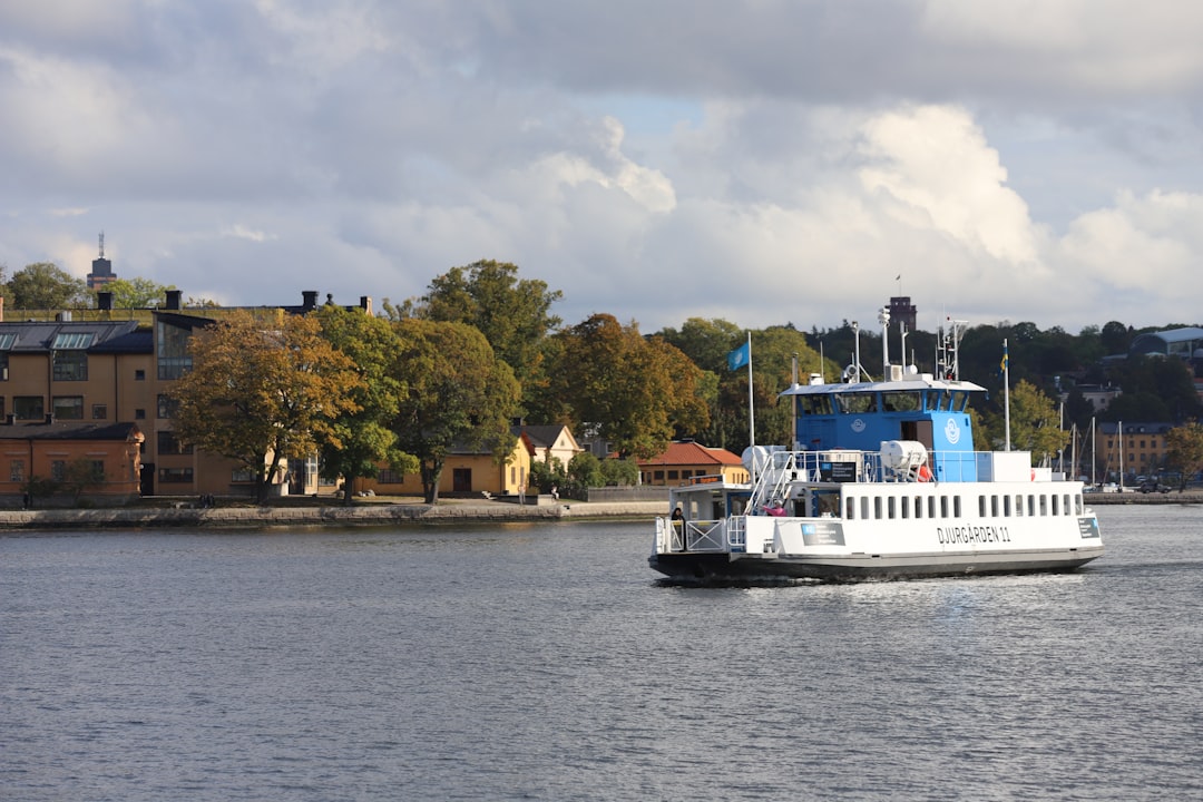 A large white boat on a large body of water, Djurgårds ferry and the Skeppsholmen island