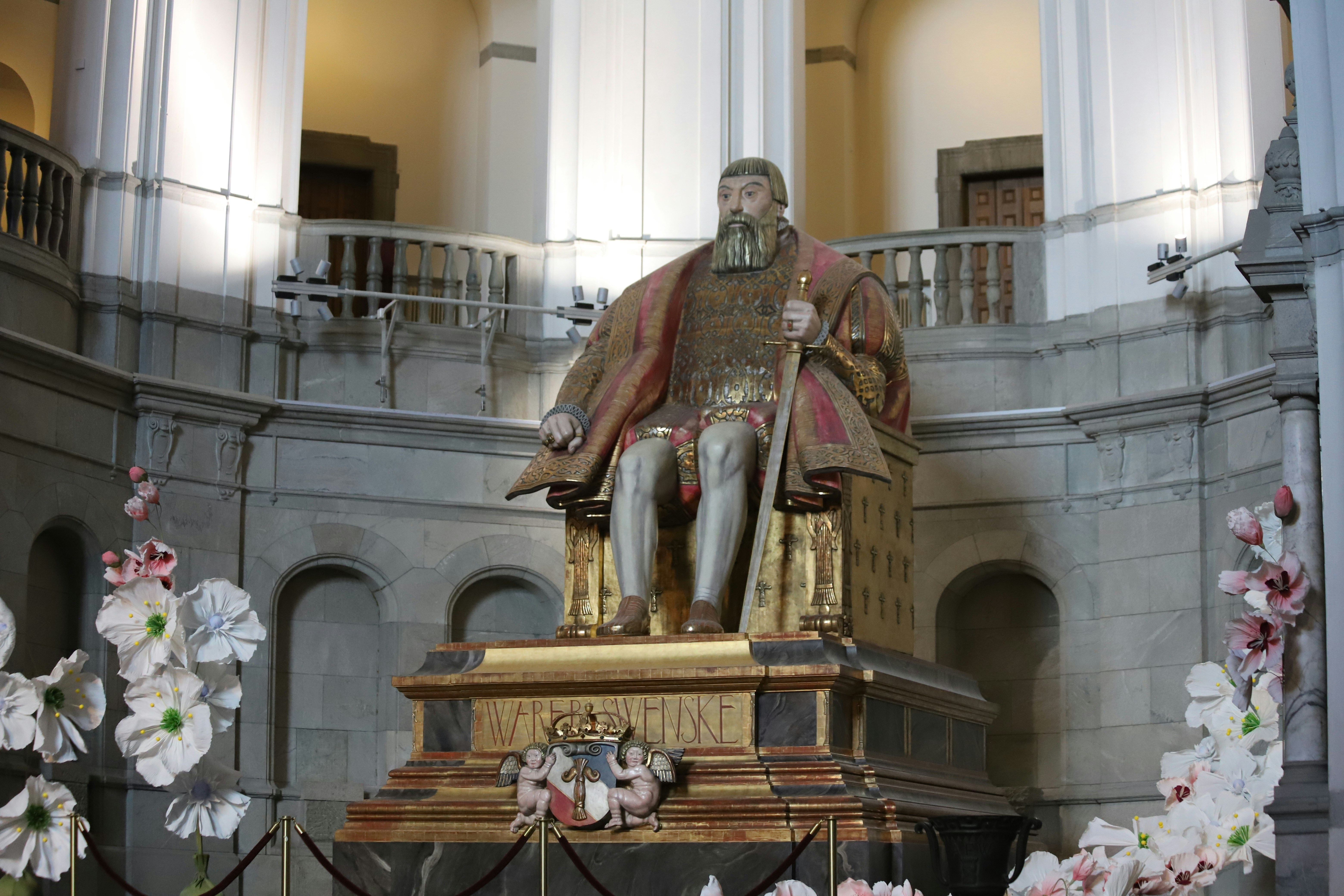 A statue of a man sitting on top of a bench