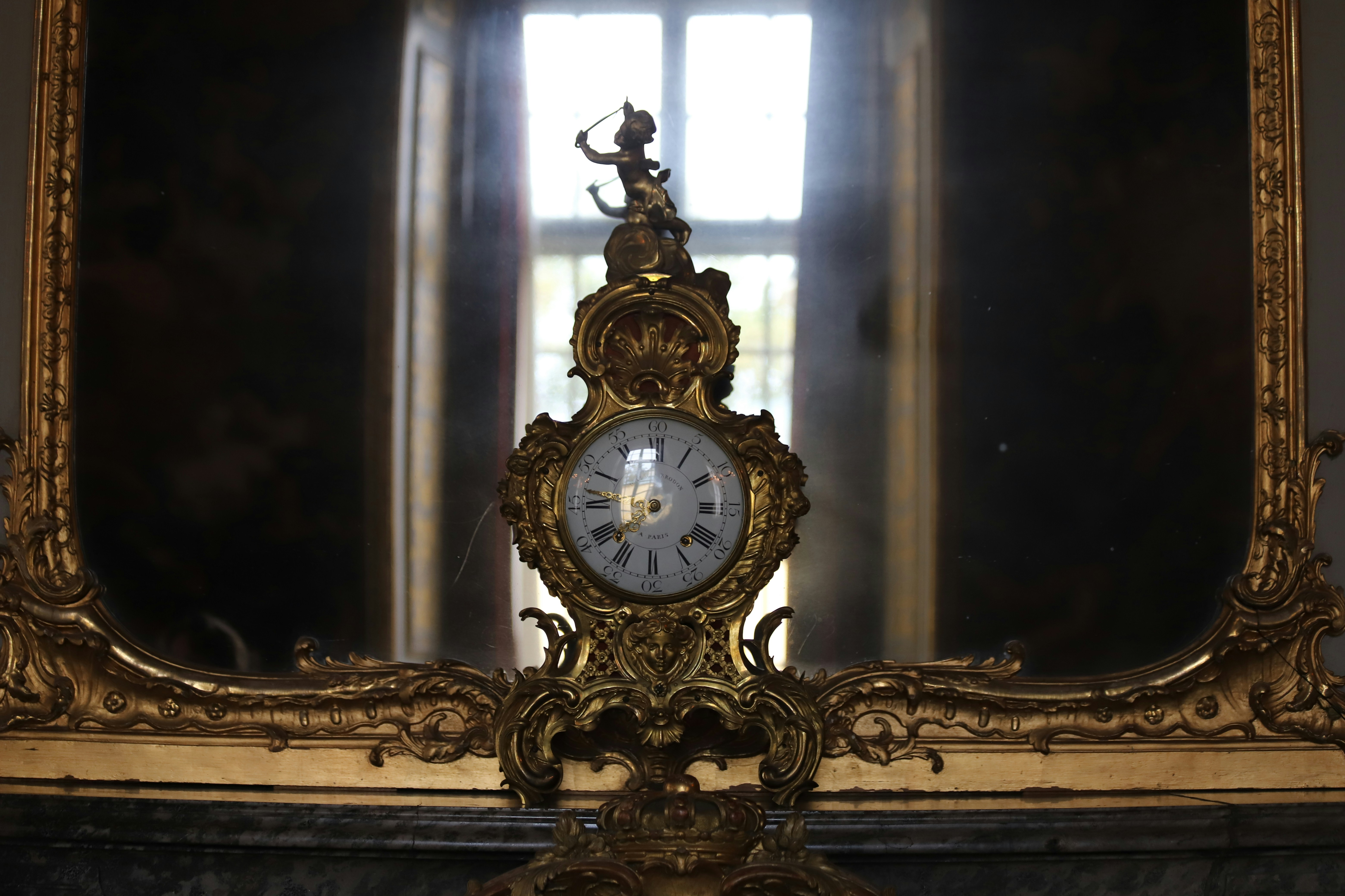 A clock sitting in front of a mirror in a room