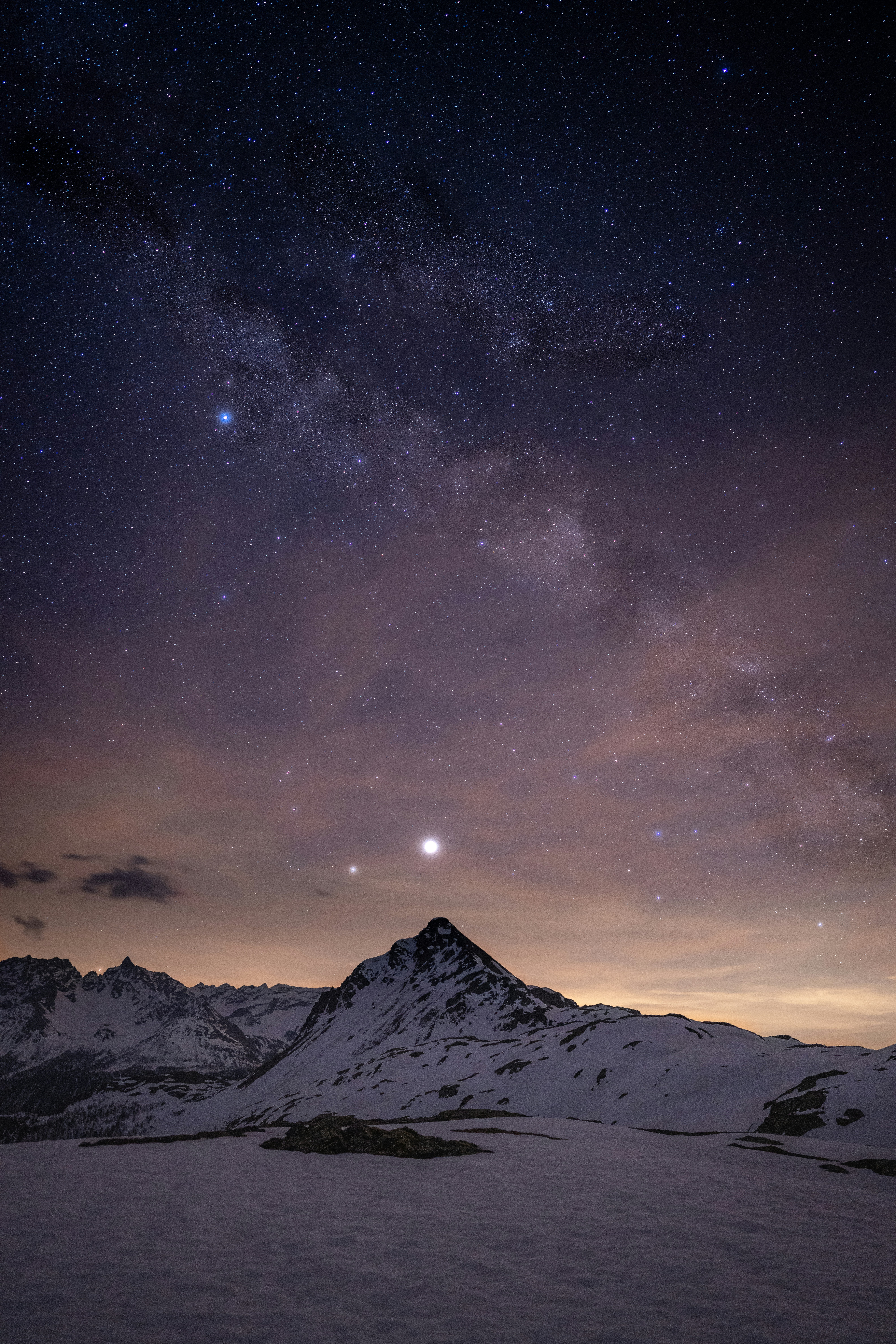 The night sky over a snowy mountain range