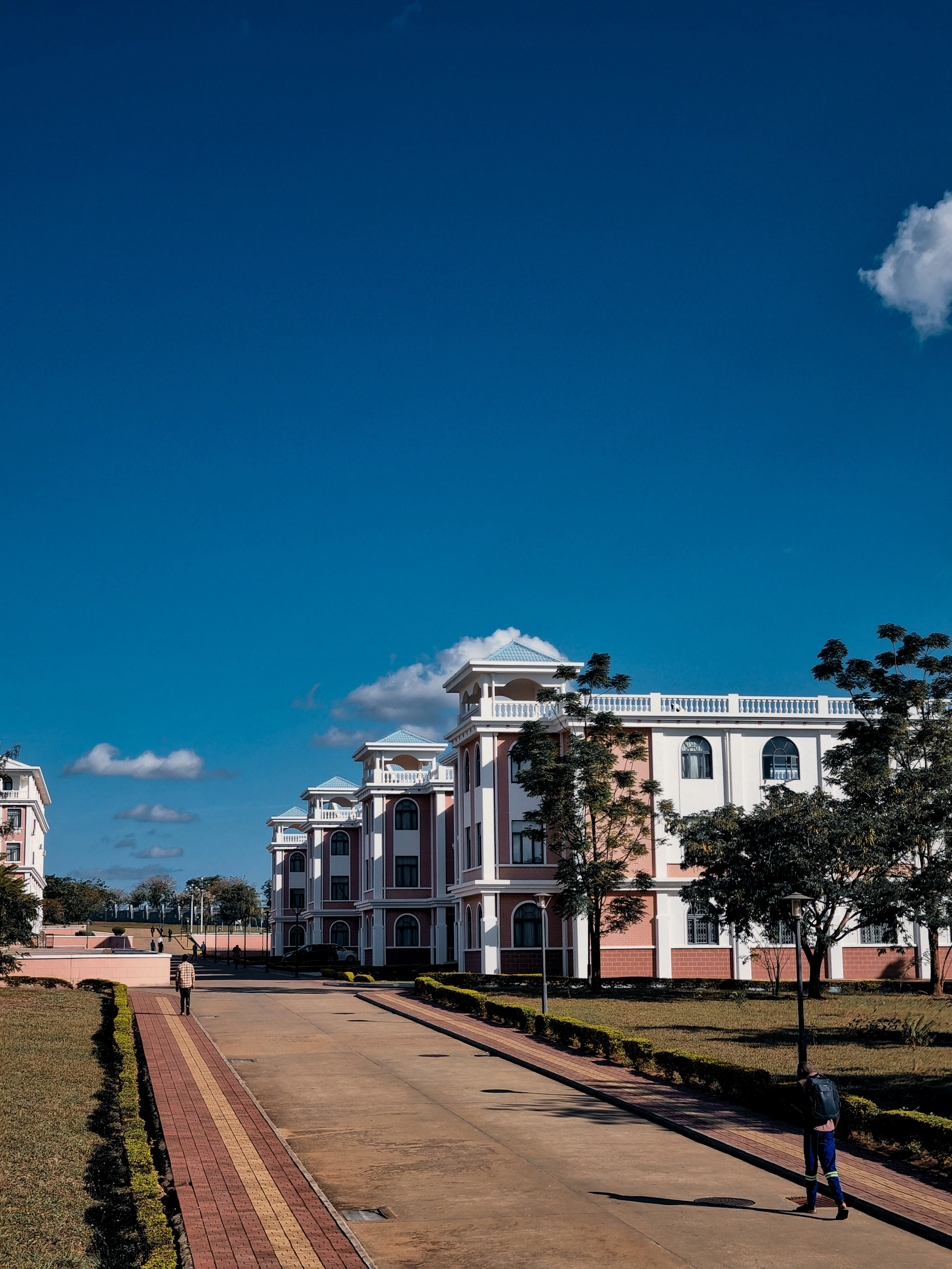A person walking down a sidewalk in front of a building