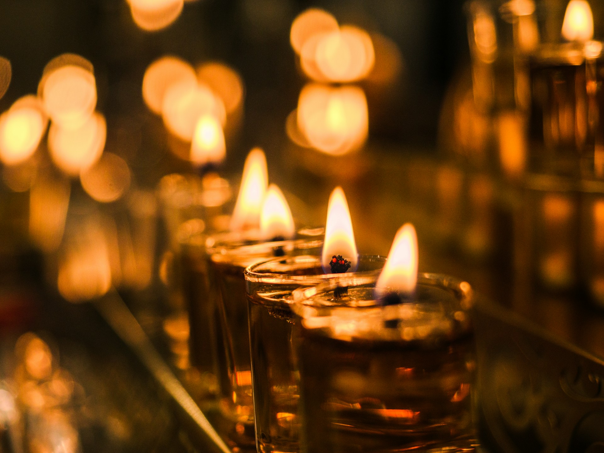 A row of lit candles sitting on top of a table