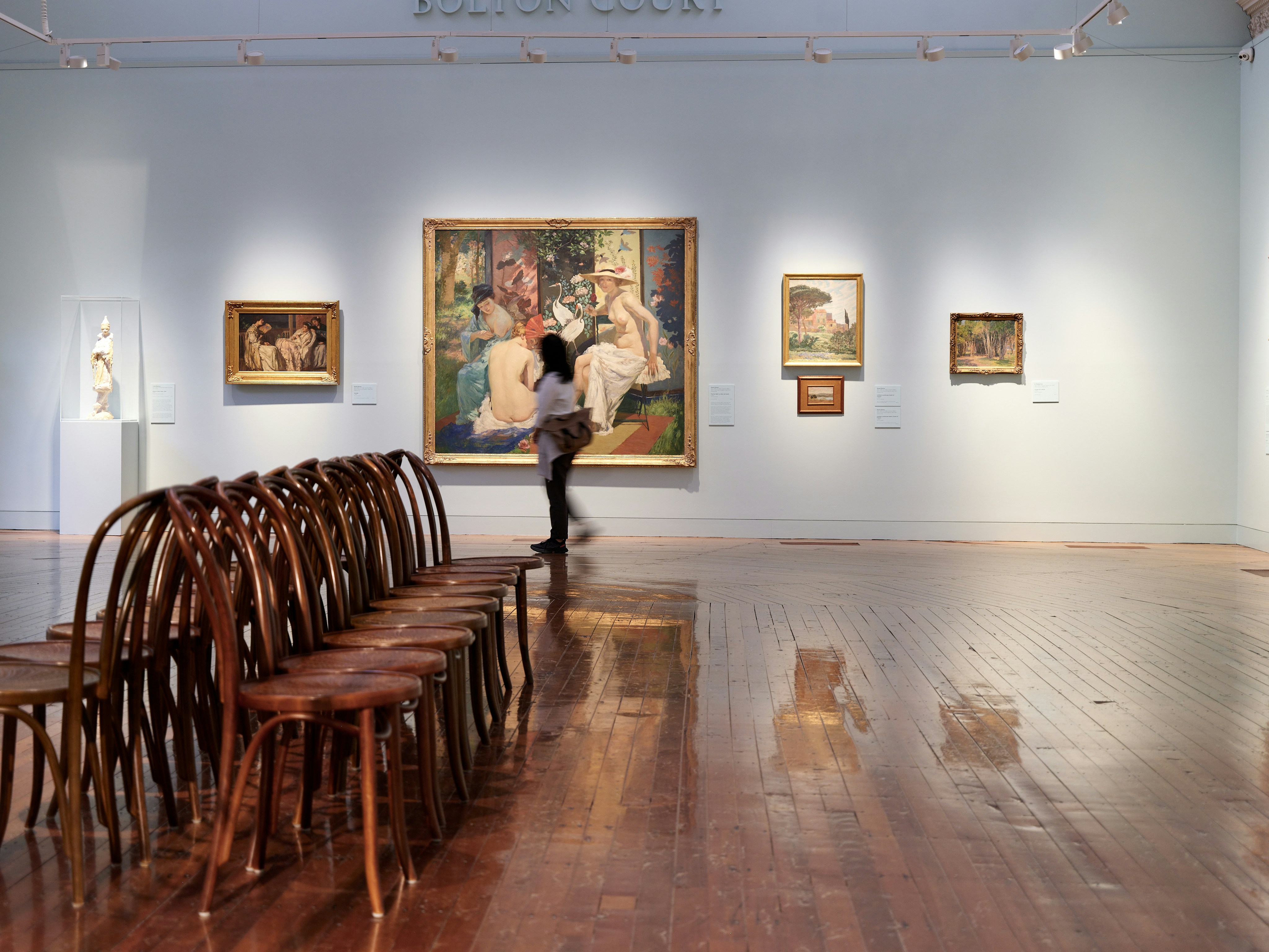 A room filled with wooden chairs and paintings