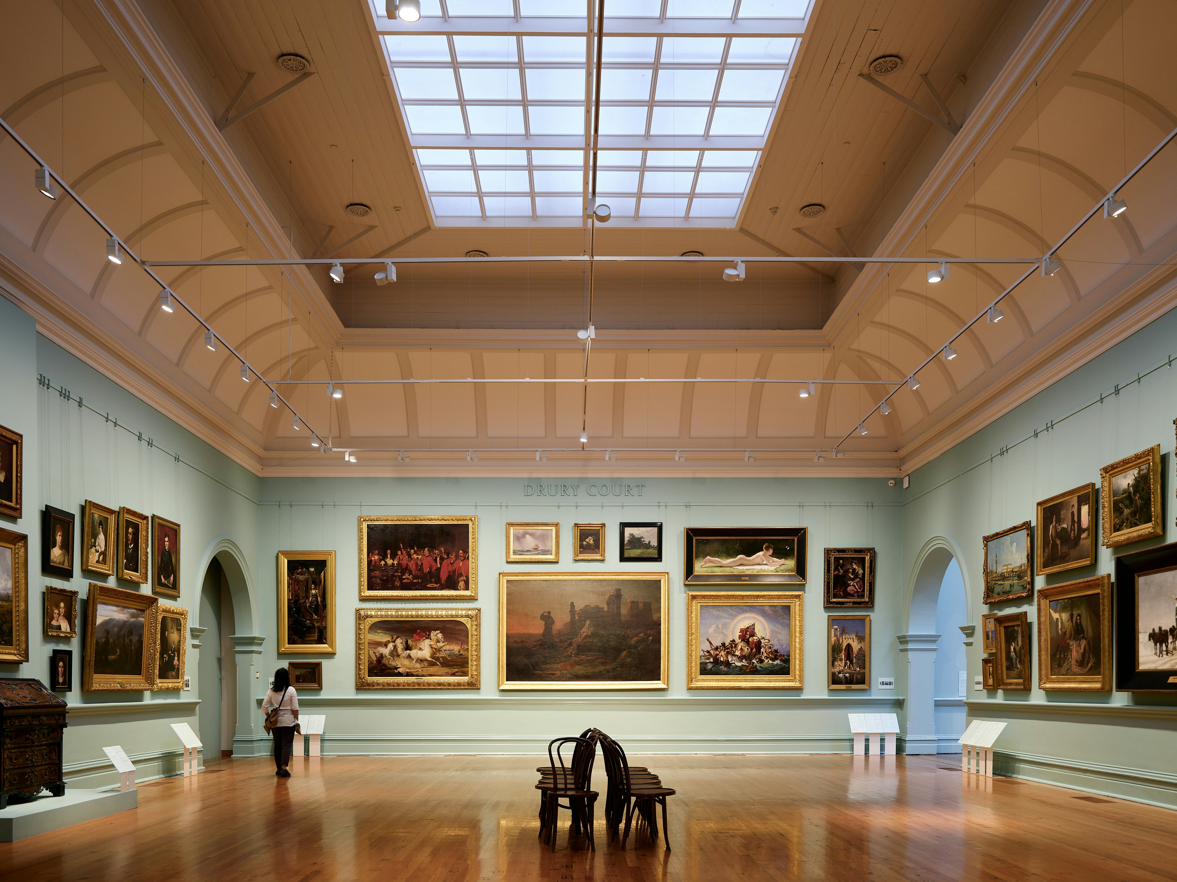 A room filled with lots of paintings and a skylight
