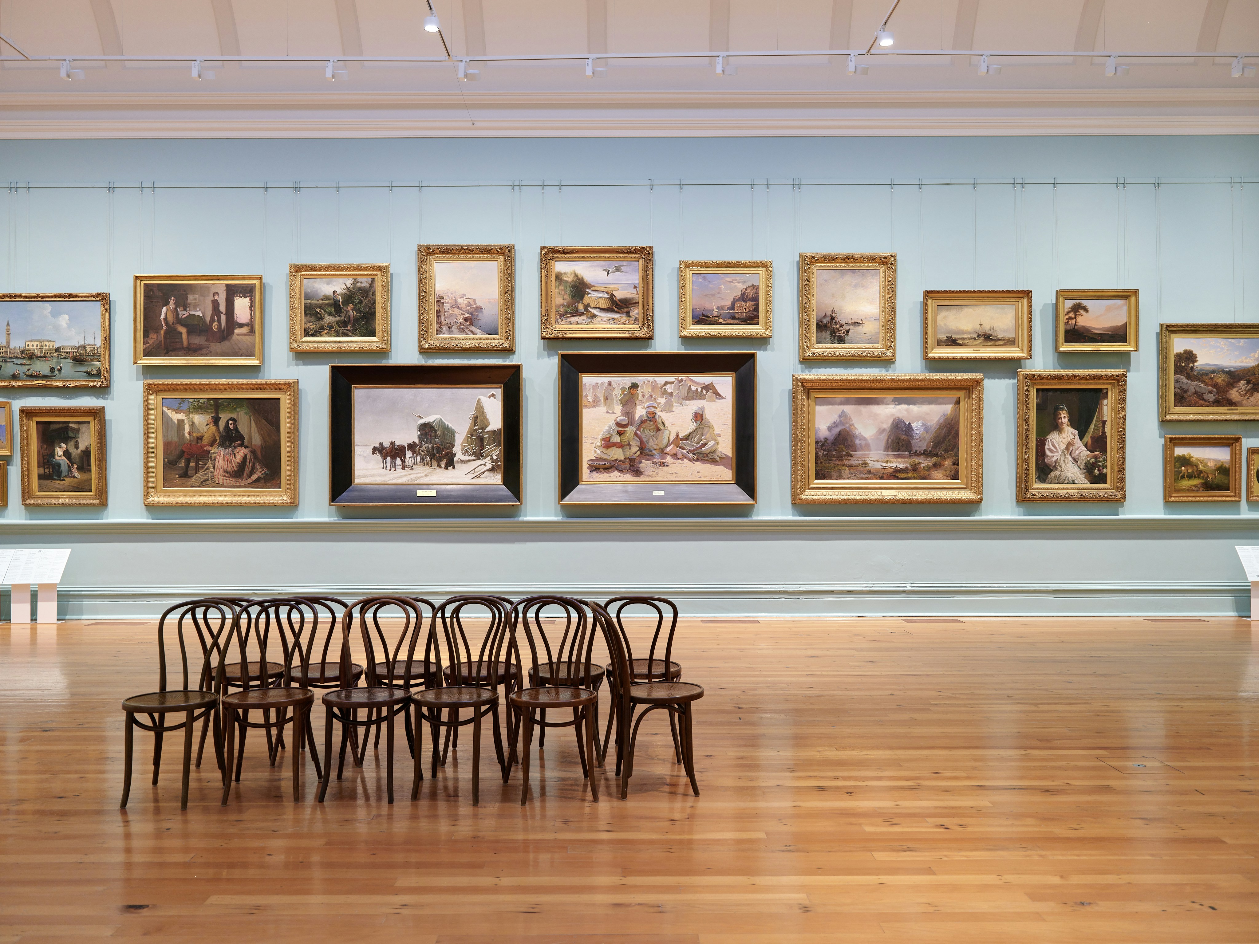 Art gallery interior with chairs and wall-mounted artwork