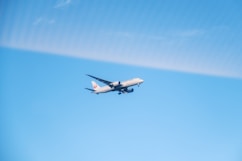 An airplane is flying in the blue sky