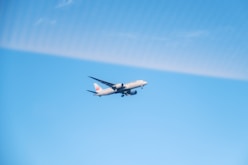 An airplane is flying in the blue sky