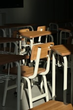 A room filled with lots of wooden desks and chairs