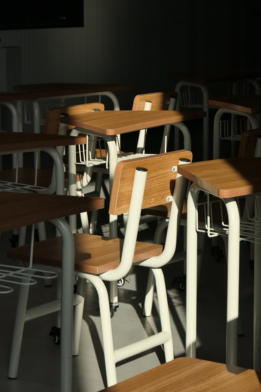 Pupitres escolares de madera apilados en un aula