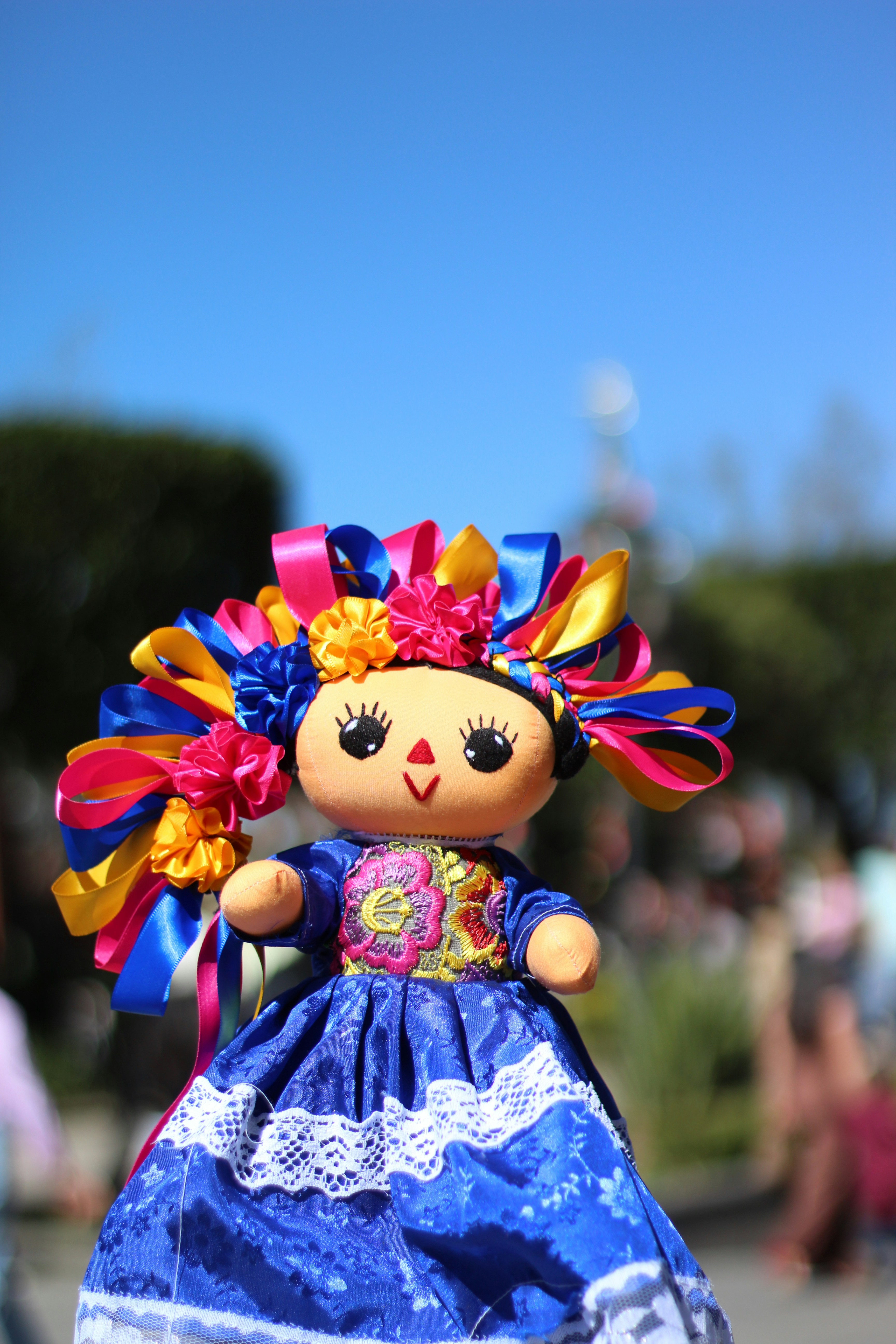 Une petite poupée avec une robe bleue et des cheveux colorés