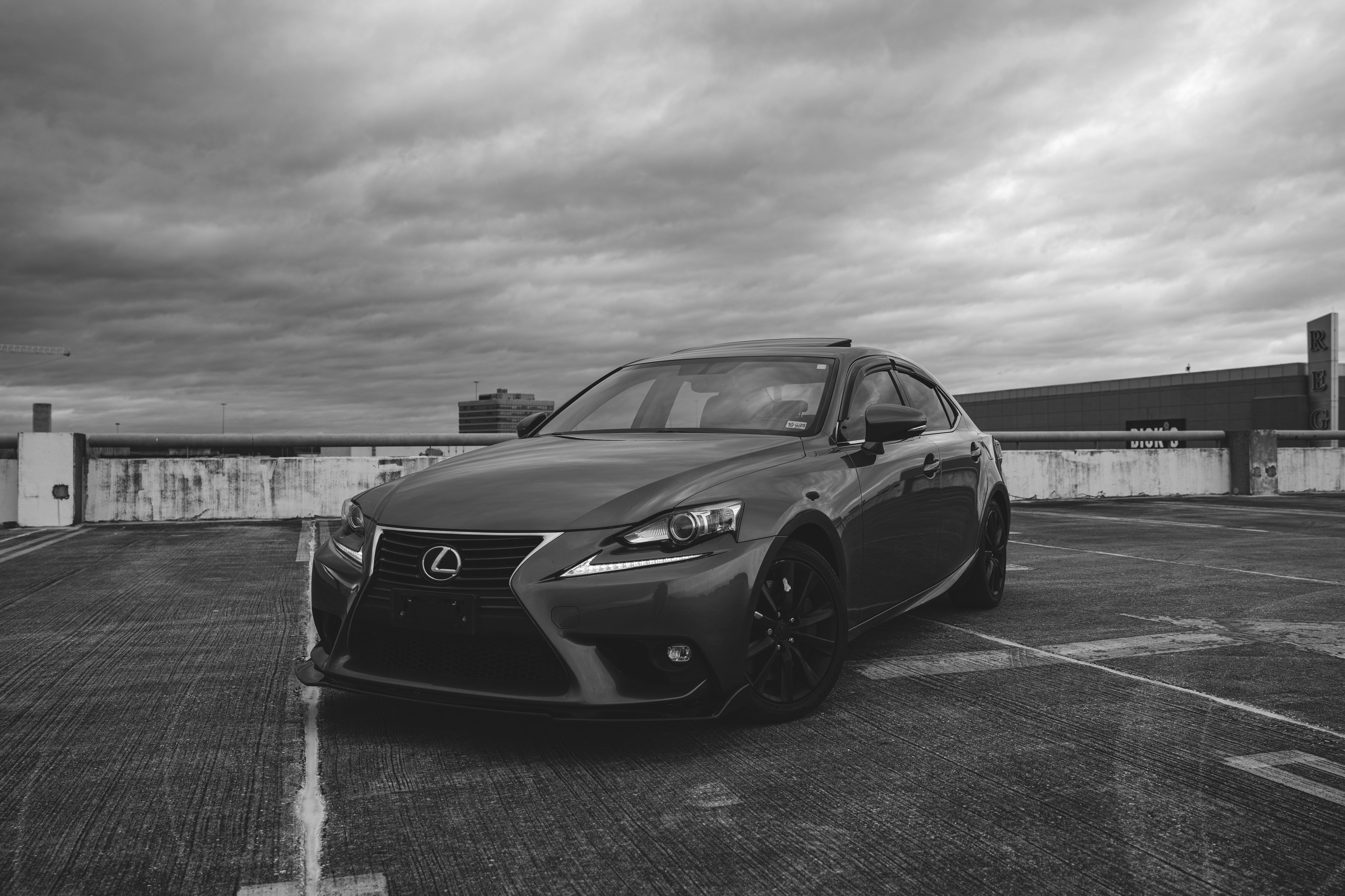A black and white photo of a car in a parking lot