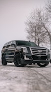 A black cadillac parked in a parking lot