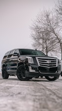 A black cadillac parked in a parking lot