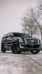A black cadillac parked in a parking lot
