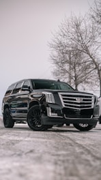A black cadillac parked in a parking lot