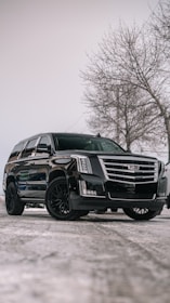 A black cadillac parked in a parking lot