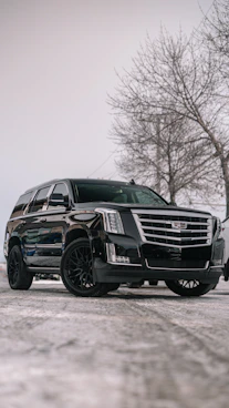 A black cadillac parked in a parking lot