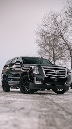 A black cadillac parked in a parking lot